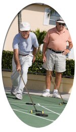 Two older adults playing shuffleboard