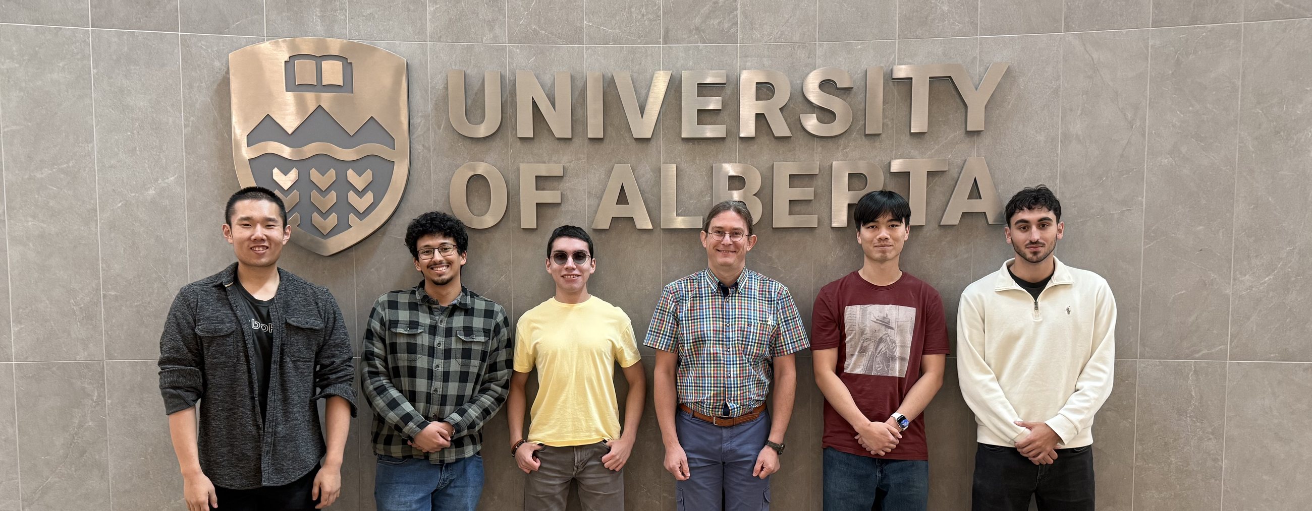 The Malykhin Lab team standing in front of the University of Alberta sign