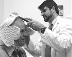 Dr. Muzaffar Siddiqui applies a head-cooling device to stroke patient Randy Greene.