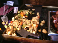 Open grill with roasted potatoes.