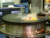 cooks grill your creation on the circular flatbed